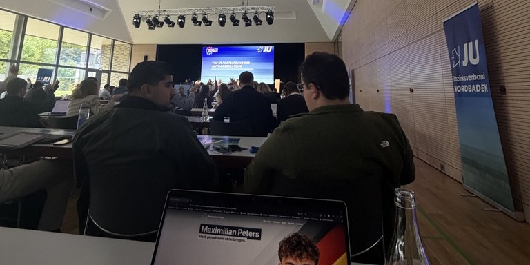 Blick in den Saal beim 54. Landestag der JU Baden-Württemberg: Delegierte stimmen ab, im Hintergrund die Leinwand mit der Tagesordnung