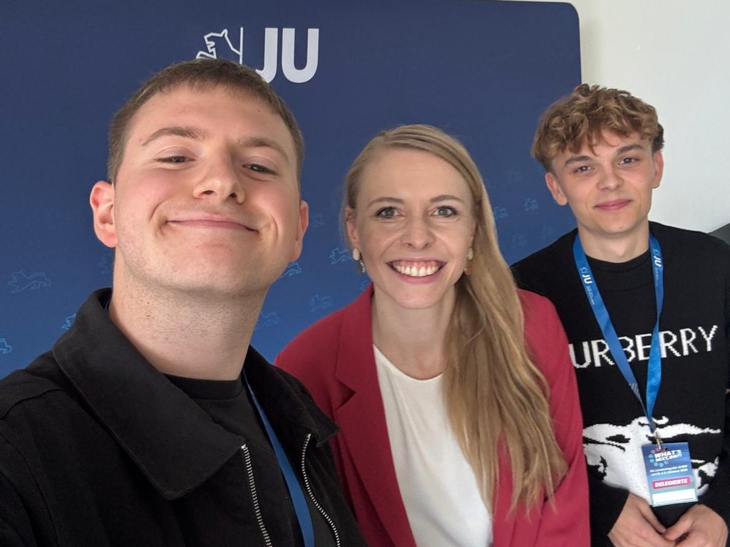 Selfie von Maximilian Peters mit Marie-Sophie Christ und Luca Fuchs vor der blauen JU-Wand beim Landestag